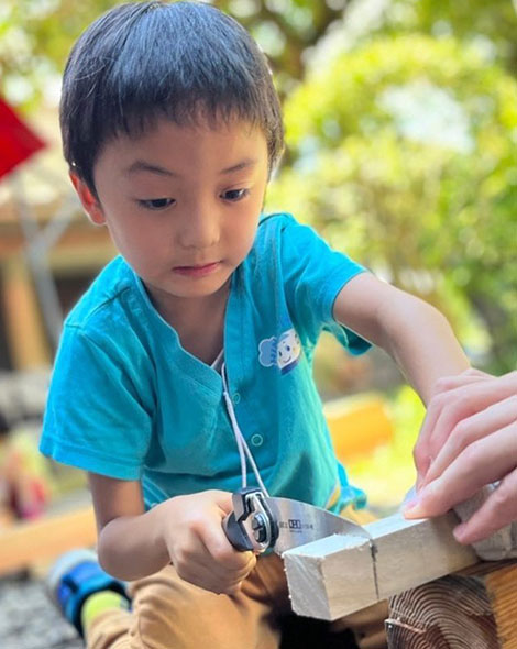 ノコギリを使う男児