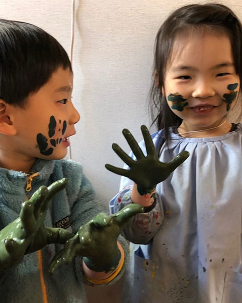 手にインクをつけた二人の子供